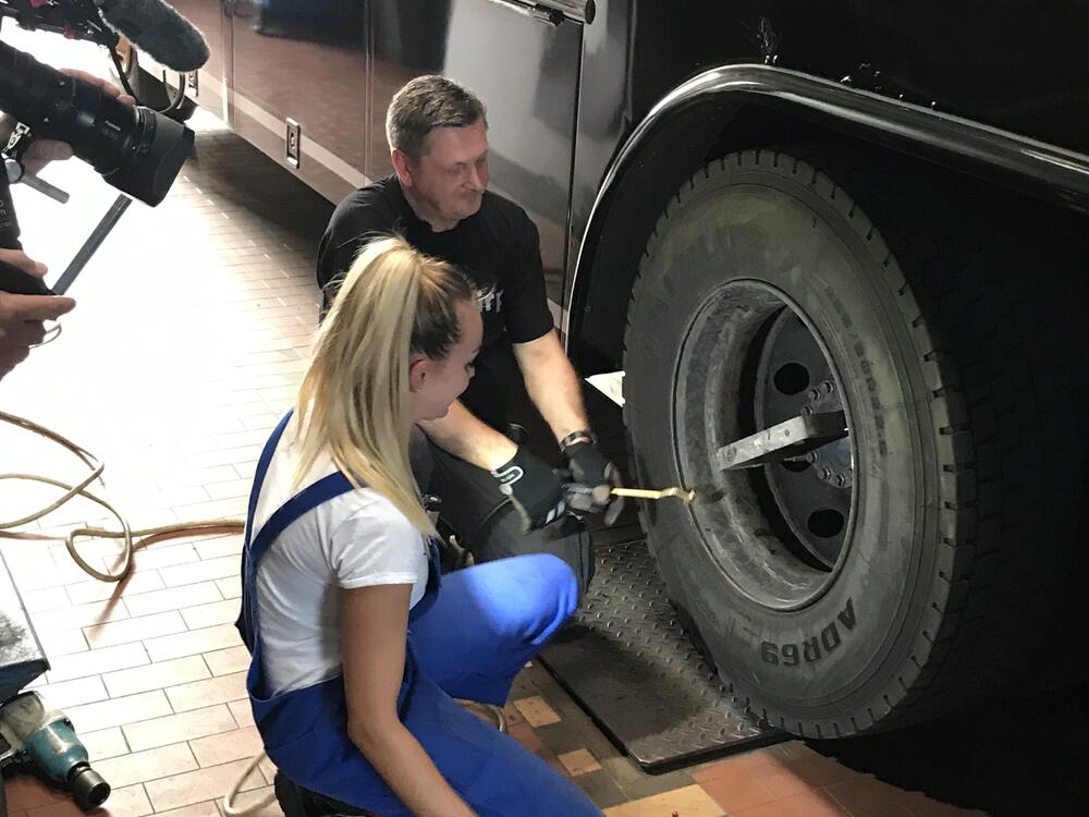 Julia lernt den Reifen zu Wechseln